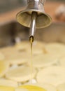 Close-up of olive oil being poured over sliced raw potatoes and onion. Cooking process
