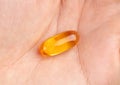 Close up of omega 3 fish oil capsule in human hand. Royalty Free Stock Photo