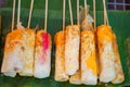 Close up omelette rolls stick on banana leaf with street food