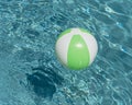 Close-up one bright green beach ball in swimming pool sunny day