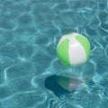 Close-up one bright green beach ball in swimming pool sunny day Royalty Free Stock Photo