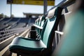 close-up of one free seat on the grandstand, with view of game in progress