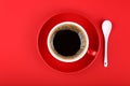 Full cup of black coffee and saucer over red Royalty Free Stock Photo