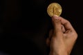 Close up one golden coin with the bitcoin symbol in hand. Young hand holding cryptocurrency coin, Money coins digital, BTC Royalty Free Stock Photo