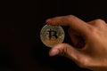 Close up one golden coin with the bitcoin symbol in hand. Young hand holding cryptocurrency coin, Money coins digital, BTC Royalty Free Stock Photo