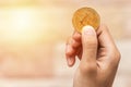 Close up one golden coin with the bitcoin symbol in hand. Young hand holding cryptocurrency coin, Money coins digital, BTC Royalty Free Stock Photo