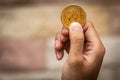 Close up one golden coin with the bitcoin symbol in hand. Young hand holding cryptocurrency coin, Money coins digital, BTC Royalty Free Stock Photo