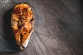 Close-up one grilled cum salmon keta fish steak on a glass transparent plate on a dark wood table background. A little Royalty Free Stock Photo