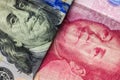 Close up of one hundred Dollar and 100 Yaun banknotes with focus on portraits of Benjamin Franklin and Mao Tse-tung/USA vs China t