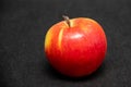 Close-up One large ripe fresh organic sweet red apple with yellow spots on a black background Royalty Free Stock Photo