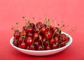 Fresh ripe bing cherries in bowl on reddish pink background