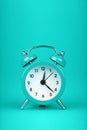 Close up one teal blue alarm clock over turquoise