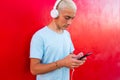 Close up of one teenager or millennial using his phone and listening music alone or watching videos - blonde man hair trendy