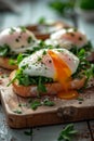 Close-up an oozing yolk of a poached egg, an Eggs Benedict recipe, presented alongside fresh greens on a toast