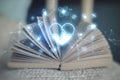 Close up of open book with glowing heart hologram on background. Cardiology and doctor`s office concept. Double exposure Royalty Free Stock Photo