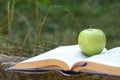 Close up of open book and green apple Royalty Free Stock Photo