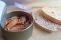 Close up of open canned tuna in red oil, fork and bread on wooden table, top view Royalty Free Stock Photo