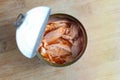 Close up of open canned tuna in red oil on wooden table, top view Royalty Free Stock Photo