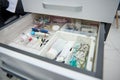 Close-up open drawer in a dentist's office with dental instruments, consumables and supplies used in a dental