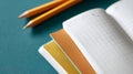 Close-up of open graph paper notebook with colored dividers and two sharpened pencils on teal surface Royalty Free Stock Photo