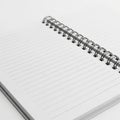 Close-up of an Open Lined Notebook with a Silver Spiral Binding on a White Background notepad Royalty Free Stock Photo