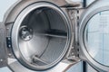 Close-up of an open shiny dryer. High-quality photo of drying drum in dry cleaner. View from inside