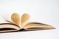 Close up of opened book with heart shaped from two pages, isolated on white background. Royalty Free Stock Photo