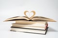 Close up of opened book with heart shaped from two pages, isolated on white background. Royalty Free Stock Photo