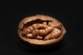 Close-up of an opened walnut. The nut kernel is still in the shell. The background is dark Royalty Free Stock Photo