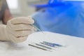 Close-up of an ophthalmologist doctor holding instruments for microscopic eye surgery in his hand over a sterile table