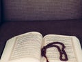 Close up oppened the holy Quran book with rosary. Prayer at Hijri New Year, August 30