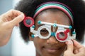 Close up opthalmology trial frame with young woman african american eye test ophthalmological in optics clinic. woman checkup eye