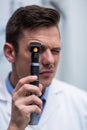 Close-up of optometrist looking through ophthalmoscope Royalty Free Stock Photo
