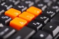 Close-up of orange arrow keys on a black keyboard, up, down, left, right buttons on a gaming computer keyboard Royalty Free Stock Photo