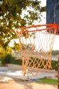 Close-up of an orange basketball net in an outdoor setting next to a pool