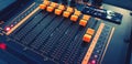 Close up orange button of sound mixer panel equipment for mixing or control audio system with red light flashing in vintage tone Royalty Free Stock Photo