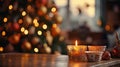 Close-up of an Orange Candle holder with some Christmas crockery put on an old wood table with a blurry Christmas tree