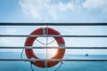 Orange lifebuoy ring hanging on ferry boat with ocean background Royalty Free Stock Photo