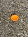 orange plastic bottle on a concrete surface with a round shape Royalty Free Stock Photo