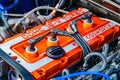 Close-up of an orange and silver Ford engine with blue hoses, FORD label, possible additional FORCE component, in a garage or Royalty Free Stock Photo