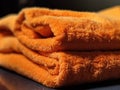 Close-up of an orange terry towel. Folded terry towel. The structure of the material absorbs water well Royalty Free Stock Photo