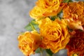 Close up orange yellow rose flowers bouquet in glass vase, grey background, day light Royalty Free Stock Photo