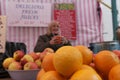 Close-up of oranges on display with senior owner in background