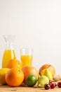 Close up of oranges, grapefruits, cherries and pears on wooden table with bottle and glass of orange juice Royalty Free Stock Photo