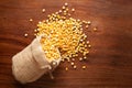 Close-up of Organic Bengal Gram Cicer arietinum or split yellow chana dal spilled out from a laying jute bag over wooden Royalty Free Stock Photo