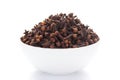 Close-up of Organic Clove Syzygium aromaticum or Indian long on a ceramic white bowl. Pile of Indian Aromatic Spice.