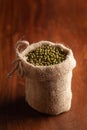 Close-up of Organic green Gram Vigna radiata or whole green moong dal in a standing jute bag over wooden brown background Royalty Free Stock Photo