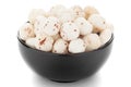 Close-up of organic makhane puffed lotus seed or Fox nuts in a black ceramic bowl over white background