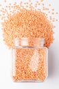 Close up of Organic masoor dal Lens culinaris or whole pink dal spilled and in a glass jar.