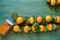 Close up of organically grown apricots and jar of apricot jam. Basket full of apricots on green wooden background Royalty Free Stock Photo